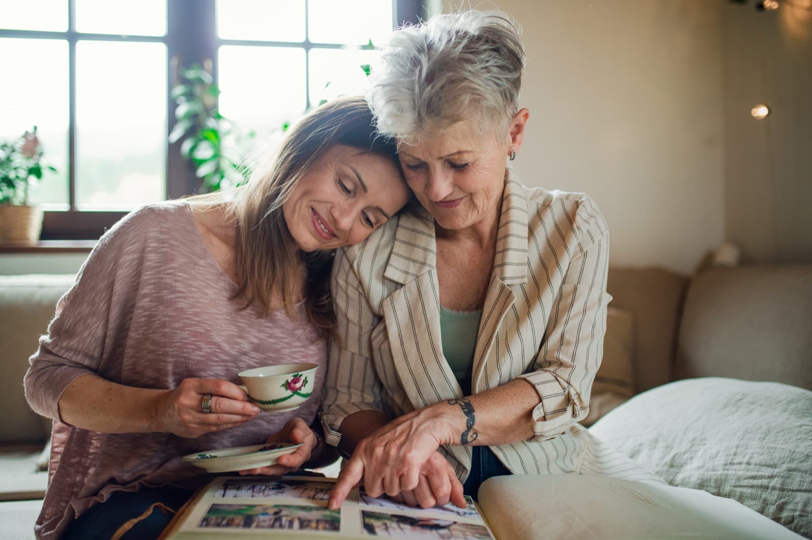 Caregiver visiting with an older adult in a bright, comfortable home